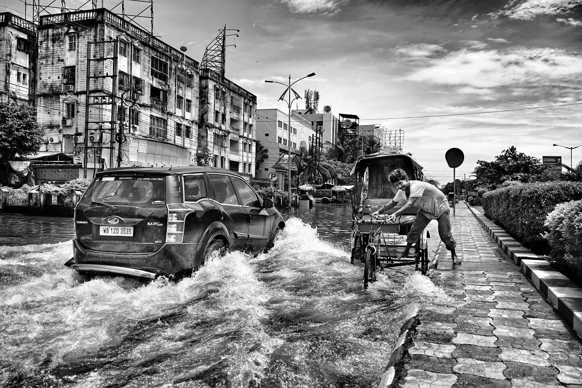Car and rickshaw on street in water during flood