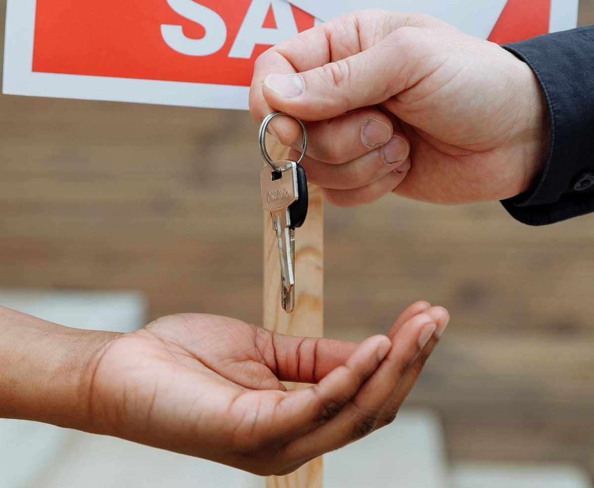 Person handing out keys to another person